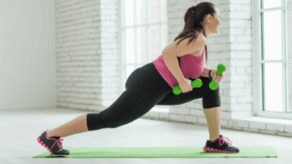 The girl performs a dumbbell exercise